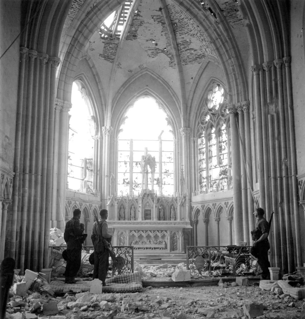 Vojáci 3. pěší kanadské divize si prohlížejí poškozený kostel Saint-Martin De La Trinite, který navštívili po operaci Windsor