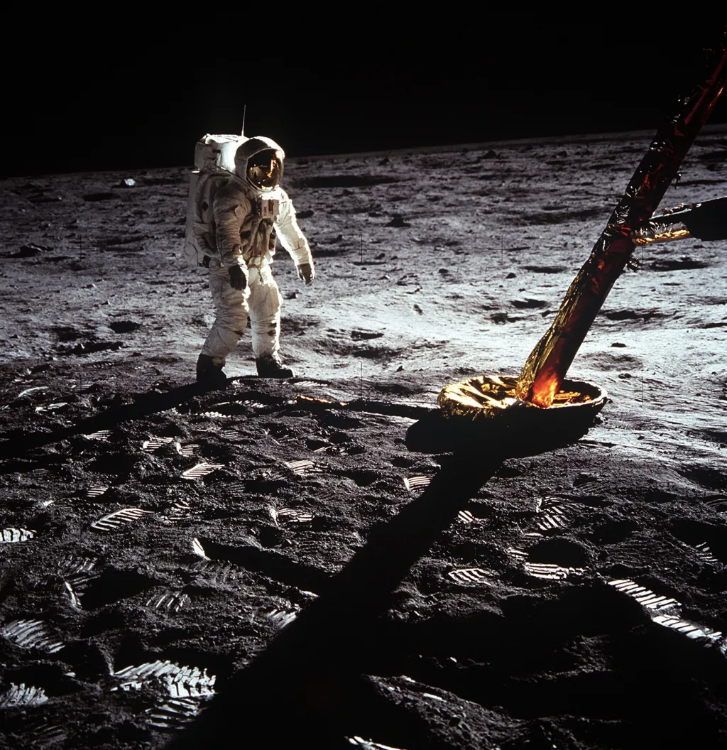 Pilot lunárního modulu Edwin E. Aldrin Jr. přechází blízko nohy lunárního modulu. Neil A. Armstrong vytvořil tuto fotografii se speciální 70mm kamerou