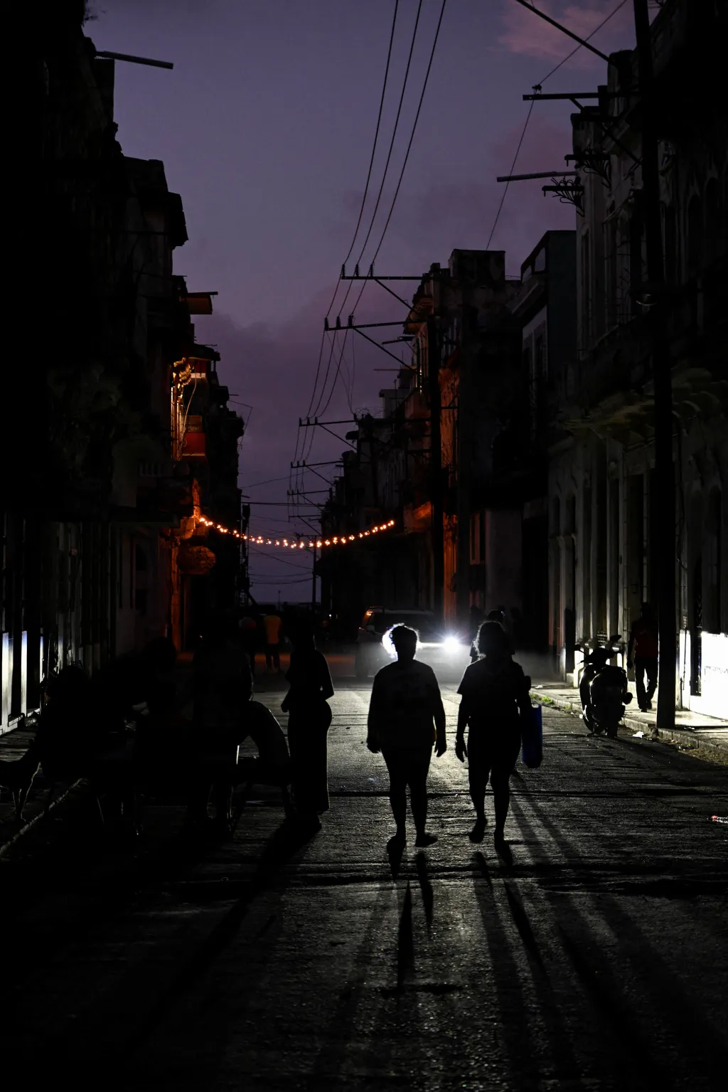 Lidé procházejí ulicemi Havany