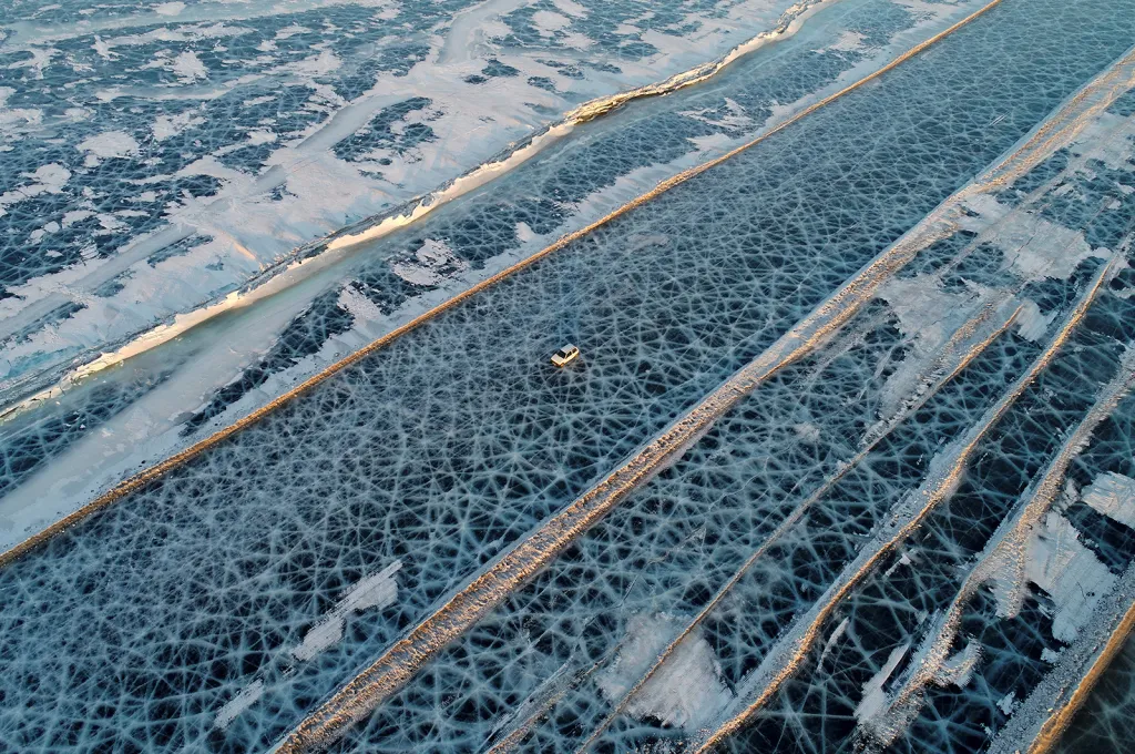 Automobil jedoucí po silnici, která spojuje oba břehy zamrzlé řeky Jenisej jižně od Krasnojarsku