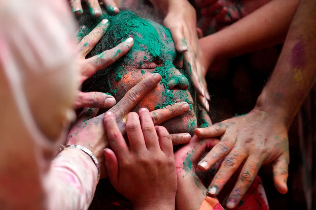 Lidé barví ženu na jedné z oslav svátku Hólí v Bombaji