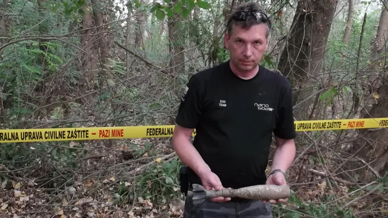 Policista ukazuje nalezenou munici