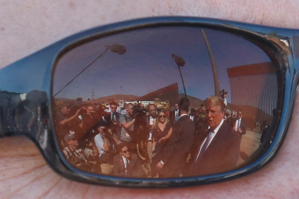 Donald Trump se zrcadlí v brýlích jedno z účastníků návštěvy amerického prezidenta u hraniční zdi s Mexikem v Otayi Mese v Kalifornii