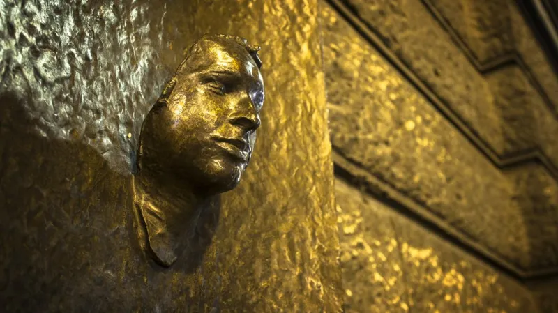 Posmrtná maska Jana Palacha na budově Filozofické fakulty v Praze.