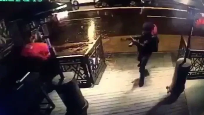 Snímek z kamery ukazuje střelce před vstupem do klubu