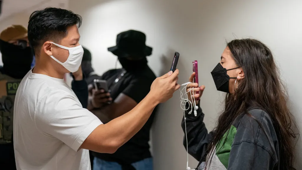 Agent ICE nahrává na telefon osobu, která zaznamenávala dění u imigračního soudu v New Yorku, 26. srpna 2025