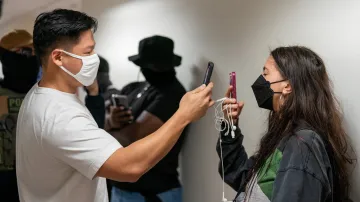 Agent ICE nahrává na telefon osobu, která zaznamenávala dění u imigračního soudu v New Yorku, 26. srpna 2025