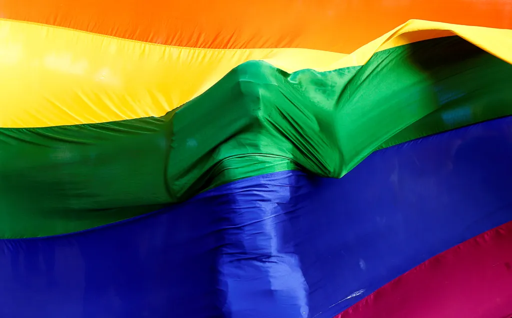 Účastník smutečního obřadu s duhovou vlajkou na památku obětí střelby v nočním gay klubu v Orlandu na Floridě. Mumbai, Indie, 2016