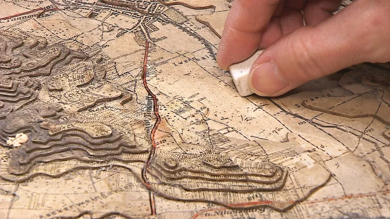 Restaurátorky mapu čistí pryží