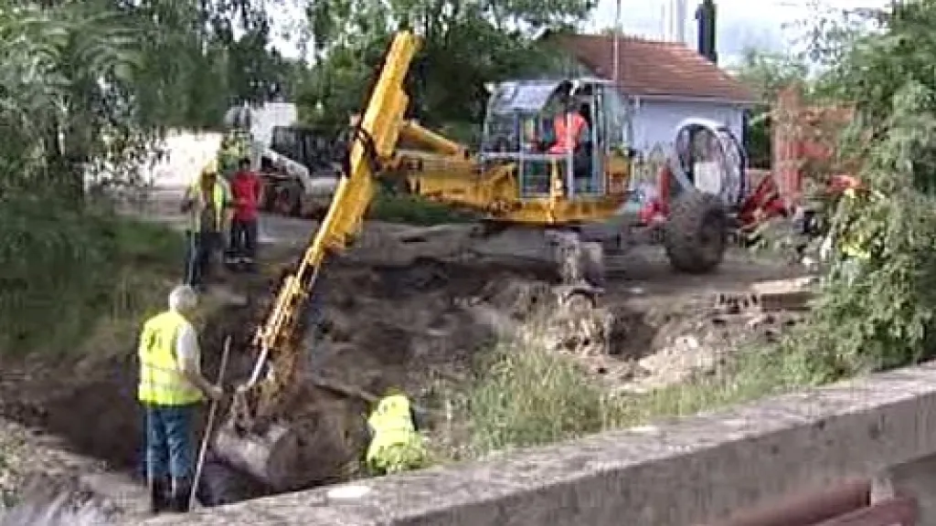 Bagr odstraňuje zeminu z břehu