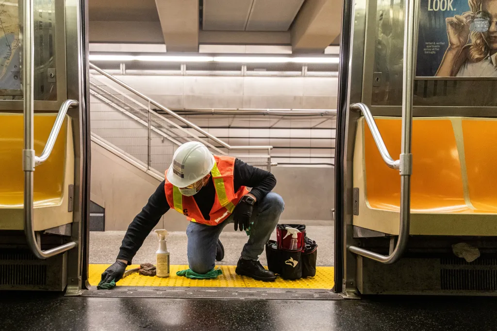 Pracovník newyorského dopravního podniku čistí vagon podzemní dráhy