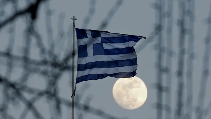Řecká vlajka vlaje za svitu měsíce v Aténách