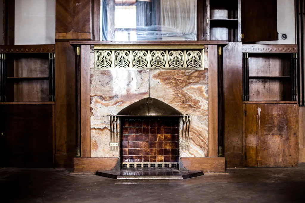 Původně neoklasicistní stavba se časem měnila. Počátkem 20. století v ní přibylo mnoho secesních prvků. Na snímku je krb ve druhém patře budovy