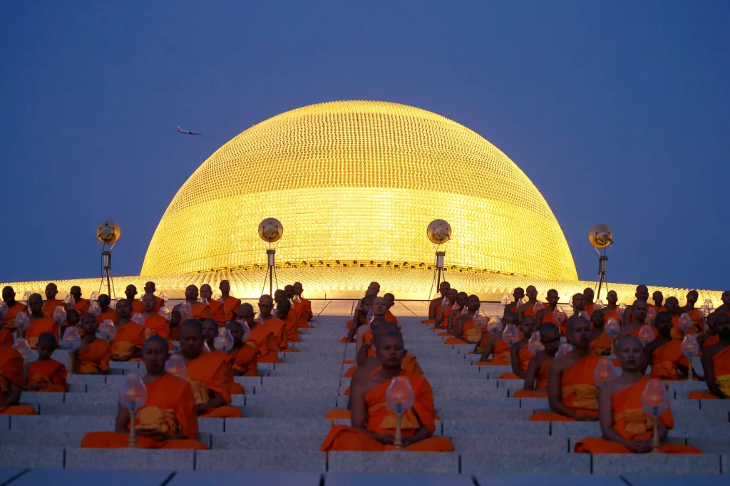 Buddhističtí mniši se modlí v chrámu Wat Phra Dhammakaya v Bangkoku během obřadu svátku Makha Bucha. Thajští buddhisté se v tento den při rozbřesku shromažďují v místních klášterech, aby tu vykonali záslužné činy