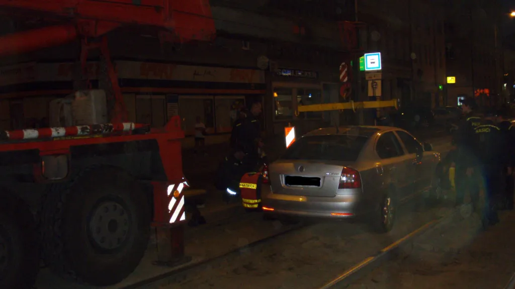 Hasiči vyprošťují auto zapadlé v kolejišti na Palackého ulici