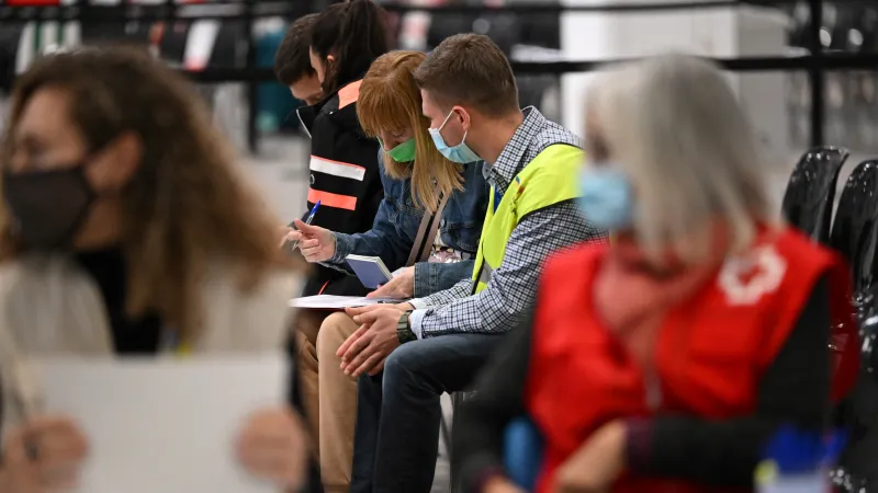 Členové španělského Červeného kříže pomáhají lidem, kteří přicházejí do přijímacího centra pro ukrajinské uprchlíky v barcelonském parku Fira 8. dubna 2022