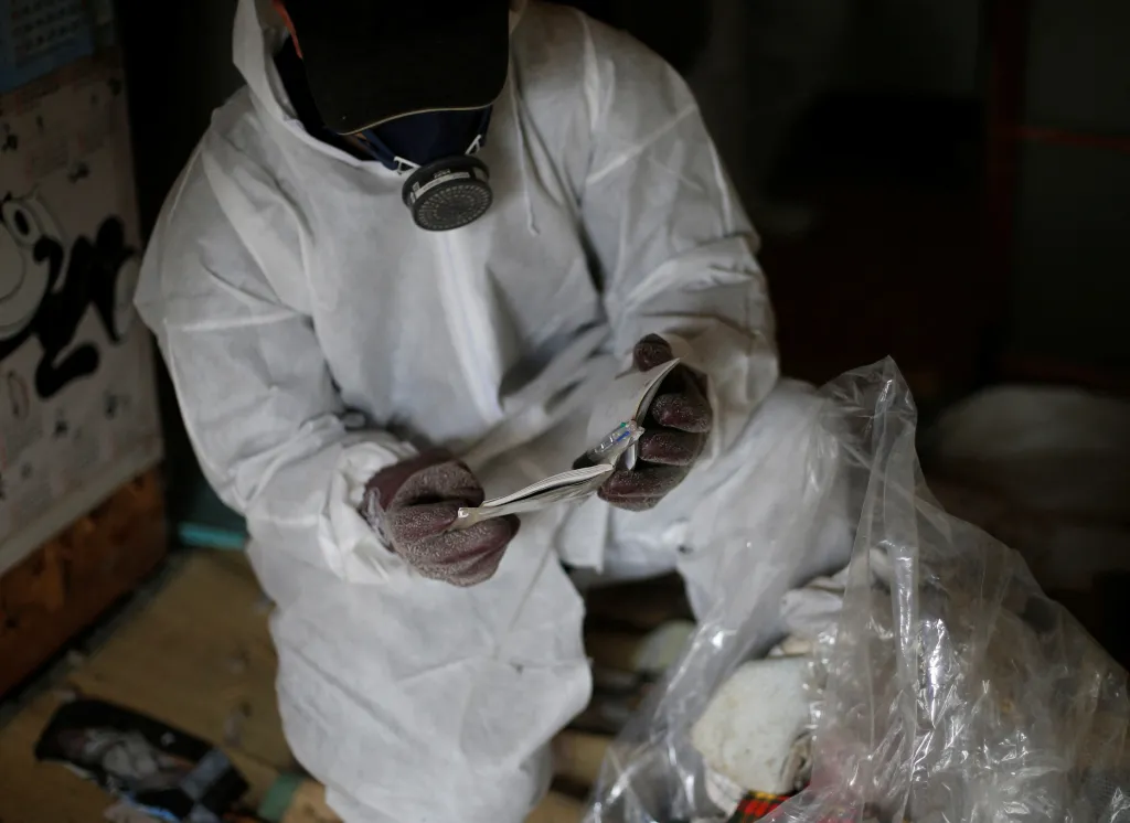 Pracovník Hirotsugu Masuda kontroluje věci, zdali v nich nejsou doklady, aby ochránil rodinu majitele před krádeží identity