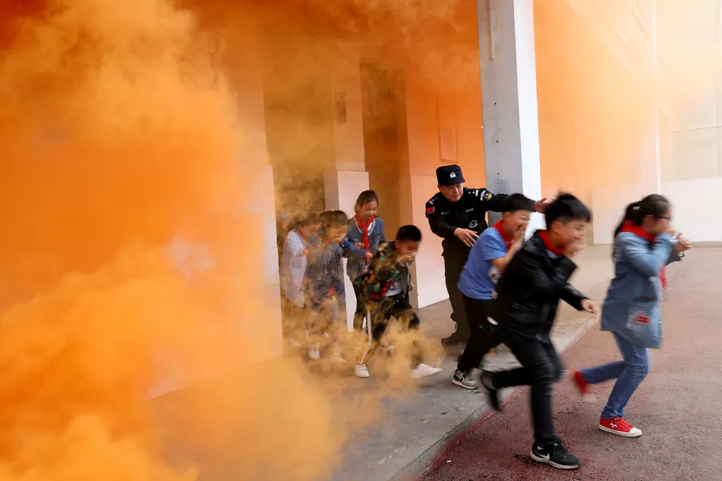 Policejní strážník a školní děti při protiteroristickém drilu na základní škole v čínské provincii Anhui.