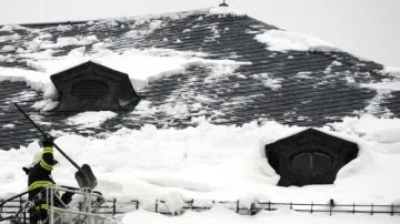Hasiči odstraňují sníh ze střech domů