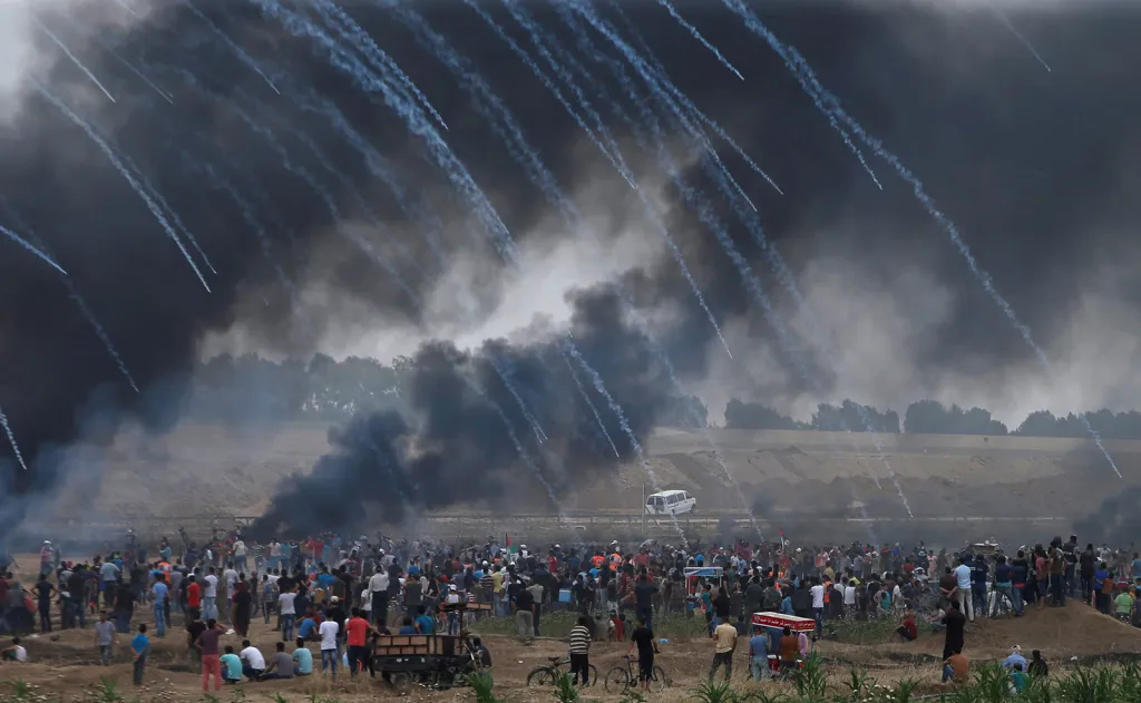 Déšť granátů se slzným plynem vypálený izraelskými vojsky na palestinské demonstranty požadující návrat do své země východně od města Gaza u hranice s Izraelem.