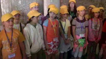 Děti zpívají v Gaudího parku v Barceloně turistům