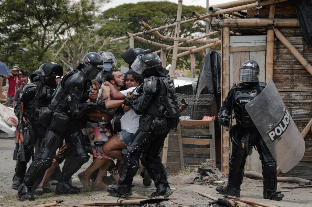 Vítězná fotografie v kategorii Jižní Amerika – singles (jednotlivé). Policisté zatýkají muže, zatímco jeho manželka a rodina protestují proti vystěhování lidí z osady San Isidro v Kolumbii