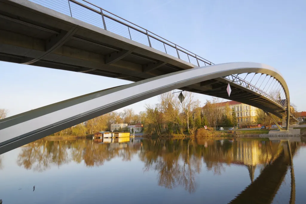 Lávka pro pěší a cyklisty spojuje historický střed města s městkou částí Zálabí. Navazuje také na cyklistické a pěší komunikace situované podél řeky Labe. Protože je situována poblíž historického obloukového mostu, je také tvořena obloukovou konstrukcí, má však větší rozpětí a podle požadavku investora je bez podpěr v řece