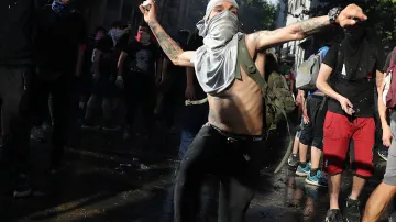 Protestující hážou směrem k policejním jednotkám kameny