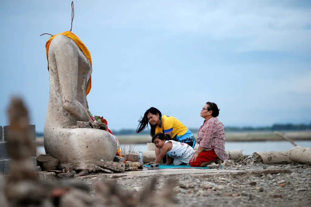 Rodina se modlí u sochy Buddhy, jež se objevila v místě přeharady, která začala vysychat kousek od thajského města Lopburi