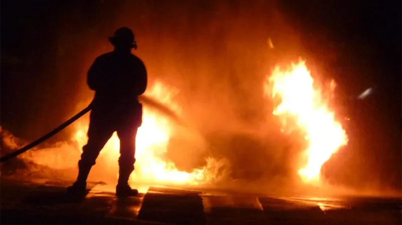 Hasič bojuje s požárem auta