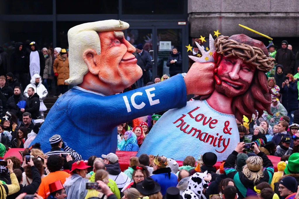 Karnevalový vůz zobrazuje prezidenta USA Donalda Trumpa, jak dává pěstí Ježíši Kristu, který má na sobě nápis Láska a humanita