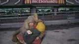 Mít soucit si málokdo může dovolit (1994). Před moskevským McDonald's, který patří k největším na světě, žebrá bezdomovkyně o pár rublů.