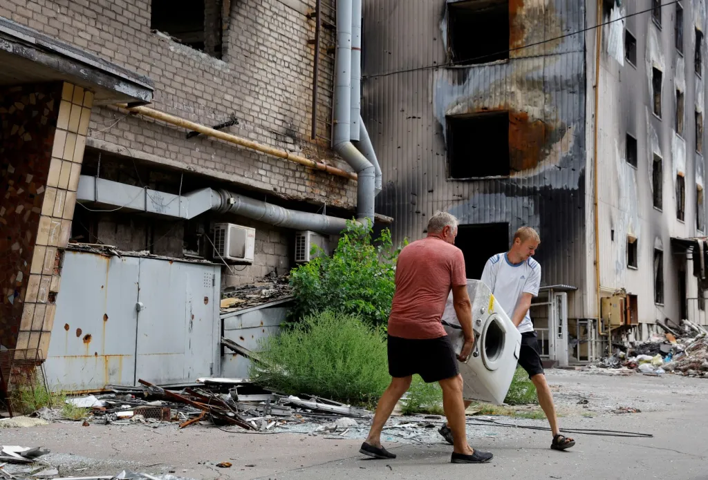 Obyvatelé Mariupolu po ničivých bojích uklízejí rozsáhlé škody