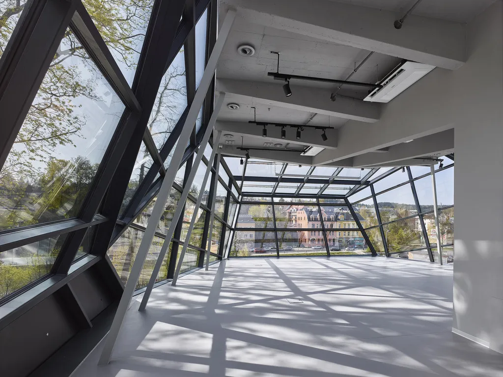Nová přístavba s prosklenou fasádou doplňuje secesní budovu muzea. Inspirována je tvarem skleněného krystalu, který je základem jablonecké bižuterie