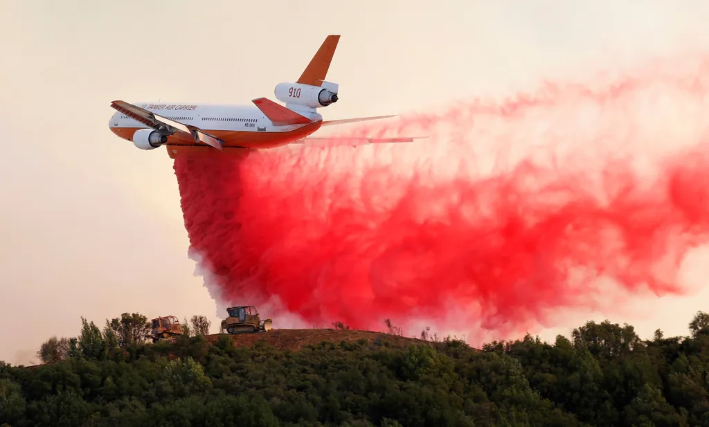 Hasící letoun DC-10 shazuje zpomalovač hoření na požárem zasažené kopce u komplexu Mendocino nedaleko města Lakeport v Kalifornii