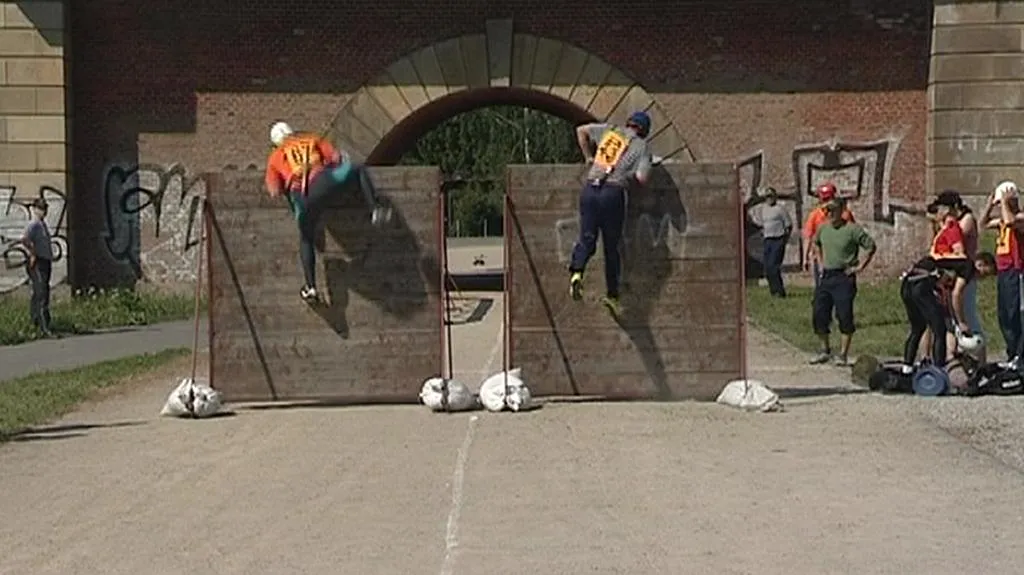 Hasiči překonávají dřevěnou stěnu
