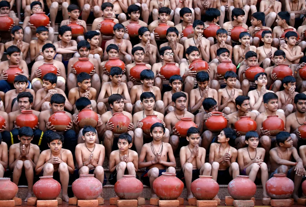 Studenti se účastní společné modlitby na každoročním hinduistickém festivalu Magh Mela v indickém Ahmedabadu