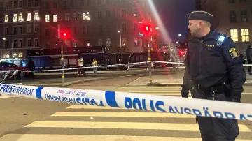 Policista stojí poblíž místa, kde autobus narazil do lidí čekajících na autobusové zastávce