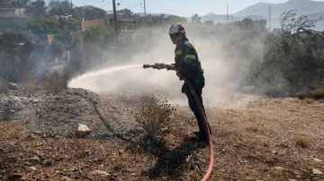 Hasič zasahuje u požáru poblíž pláže Triopetra na Krétě