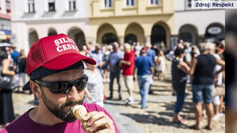 Policista v civilu s propagační čepicí politické strany ANO