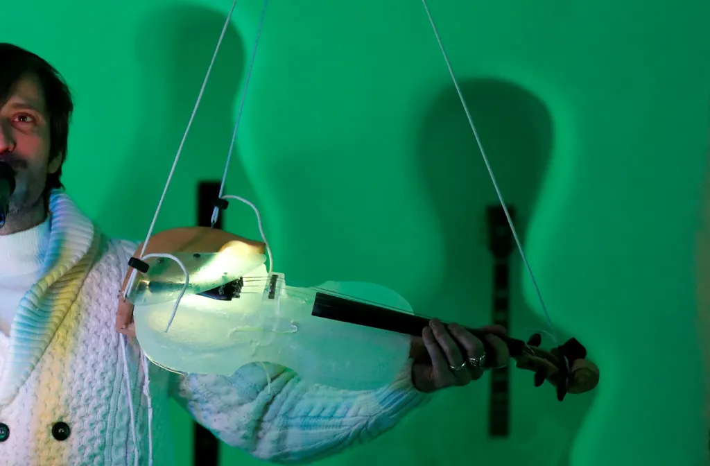 Hudebník hraje na housle z ledu během vystoupení na festivalu ledové hudby v iglú ve výšce 2600 metrů nad mořem na ledovci Presena v Itálii