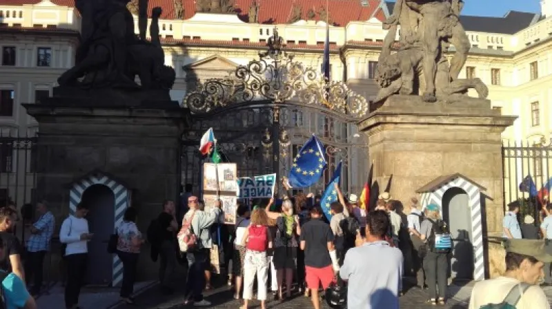Příznivci Merkelové mávají vlajkami vedle hlavní brány Pražského hradu. Zdroj: ČTK