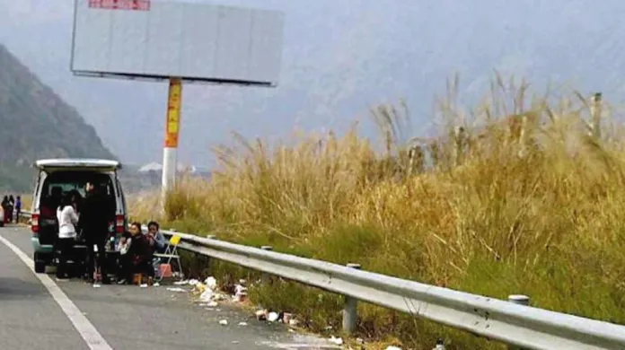 Čínská rodina piknikující na okraji dálnice