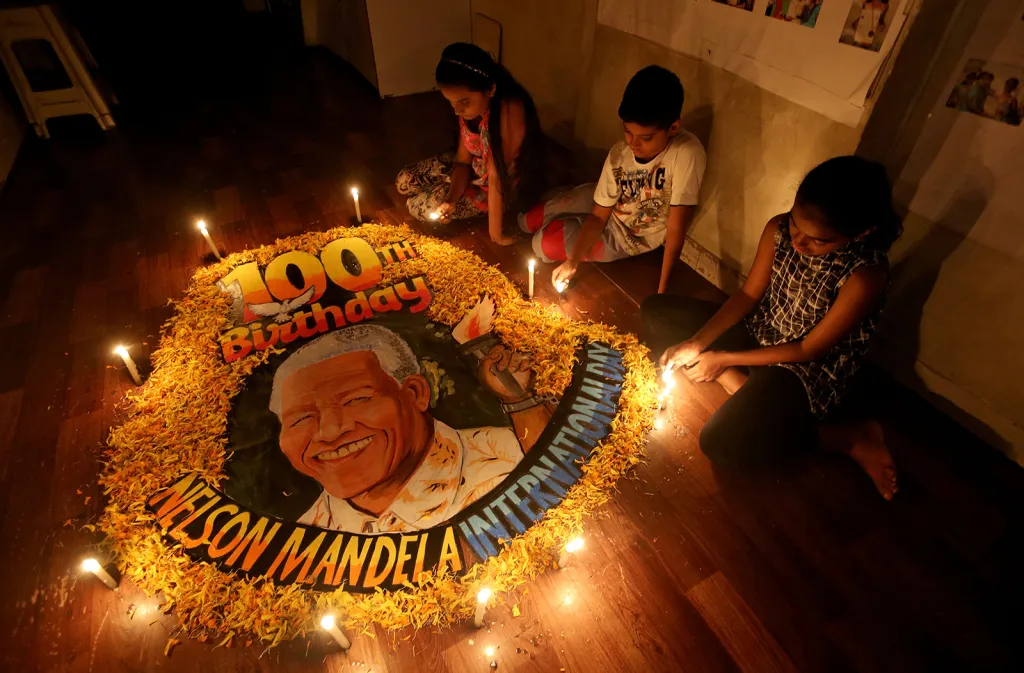 Děti ve škole v indické Mombaji zapalují svíce na počest 100. výročí narození Nelsona Mandely
