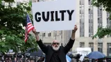 Demonstrant drží plakát před trestním soudem na Manhattanu