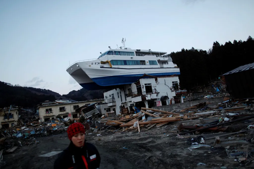 Člen týmu Červeného kříže prochází místem, které bylo zasaženo silným zemětřesením v Otsuchi v severním Japonsku. Snímek z 28. března 2011