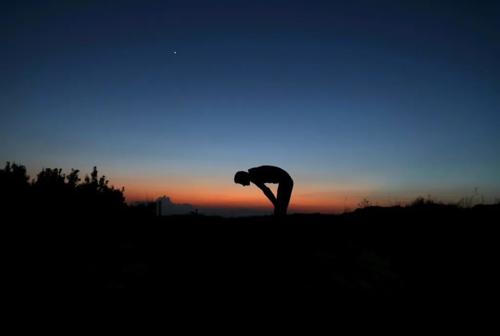 Voják Svobodné syrské armády při modlitbě po jídle s názvem iftár (první jídlo po západu slunce) během postního měsíce ramadánu.