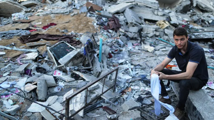 Palestinec u rozbombardovaného domu