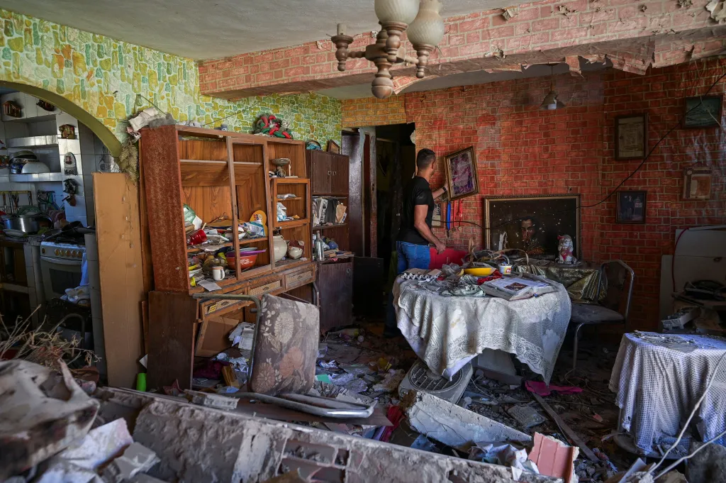 Jesus Linares uklízí svůj byt, který byl poničen střelou během amerického útoku na Venezuelu