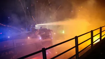 Ohňostroj poblíž policejního vodního děla použitého proti demonstrantům v Miláně